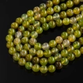 Macro shot of high-quality green agate beads with polished texture and ice-crack pattern - Apple Green Agate