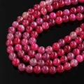 Detailed macro view of spiral wound red dragon vein agate beads with high luster on black - Rose Red Dragon Vein Agate