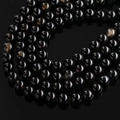 Macro detail of polished black dragon vein agate beads with unique crackle texture - Natural Black Onyx
