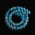 Macro detail of blue glass phantom crystal beads with internal textures on black surface - 6.5MM / Blue Ghost