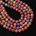 Makroaufnahme bunter kaiserlicher Steinperlen in Rot Blau und Lila mit Blumenmustern - 6.5mm (ca. 64 Perlen) / Rotgrüner Kaiserstein