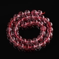 Macro shot of translucent pink phantom quartz beads with natural mineral textures - Red Ghost