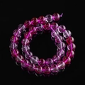 Macro shot of purple phantom glass beads with internal ice crack texture on black mirror - Rose Red Ghost