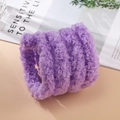 Detailed close-up of soft purple coral fleece headband material on a stylish table - Purple