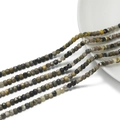 Macro detail of 3mm faceted natural stone cube beads in earthy tones on yellow string - Bumblebee Jasper