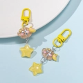 Detail of coffee resin cloud and yellow glitter star charms on yellow metal keychains - Yellow