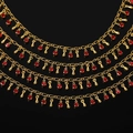 Gros plan détaillé d'un collier multicouche doré avec cristaux rouges et breloques gouttes - 1m / Or Brillant - Zircon Goutte d'Eau