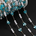 Macro detail of DIY jewelry chain with white pearls, blue butterfly beads, and gold links - 1m / KC Gold Blue