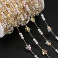 Detailed close-up of DIY pearl and AB crystal butterfly chain on a white plastic roll - 1m / KC Gold Yellow
