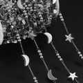 Vista macro de cadena de acero inoxidable con dijes de estrella y luna sobre negro - Estilo Estrella Y Luna (JCXZ-14) / 1m / Color acero