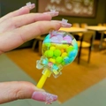 Close-up of colorful liquid sand lollipop pendant with small beads and blue bow detail - No Keychain / Yellow Color Bean Lollipop