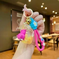 Detalle de llavero de oso rosa con lentejuelas doradas y correa de mano con margaritas - Oso De Fresa De Pvc Que Brilla En La Oscuridad [inodoro Amarillo]