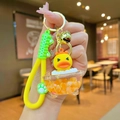 Detail of creative yellow duck keychain with silicone strap, bell, and green cat paw charm - Luminous Orange Bathtub Yellow Duck
