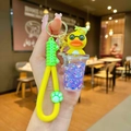 Detail of yellow duck bubble tea keychain with purple sequins and green silicone wrist strap - Luminous Purple Milk Tea Cup Yellow Duck