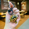 Nahaufnahme der Glitzer-Schildkröte-Schlüsselanhänger mit goldenen Pailletten und Blumen - Farbige Hardware Leuchtende Funkelnde Schildkröte / Schwarz