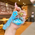 Detail of blue liquid sand heart keychain with silicone Sakura strap and gold bell - Sakura Strap Blue