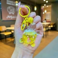 Detail eines gelben Bären Schlüsselanhängers mit flüssigem Glitzer und Kirschblüten - Farbige Hardware Leuchtende Funkelnde Schildkröte / Gelb