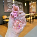 Détail d'un porte-clés tortue rose avec sable pailleté liquide et petite clochette - Rose
