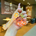 Close-up of Sakura themed heart keychain with wings, liquid glitter, and orange strap - Sakura Strap Orange