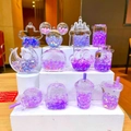 Vue de 11 charmes de sable liquide violet aux formes assorties de château et d'étoile - Perle de Bulle Lumineuse Violette