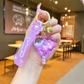 Detailed macro of a purple cherry blossom heart keychain with Sakura wrist strap and bell - Sakura Rope - Purple