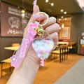 Close-up of pink cherry blossom acrylic heart keychain with liquid glitter and sakura strap - Sakura Strap-White