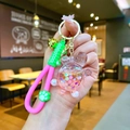 Macro shot of creative pink turtle keychain with liquid quicksand and colorful glitters - Wristband Pink Quicksand Turtle