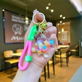 Detail of creative liquid turtle keychain with pink silicone strap and golden bell - Wristband Colorful Quicksand Turtle
