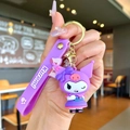 Detail shot of a purple Kuromi silicone keychain with a hand strap and gold metal ring - Purple Kuromi (Bowtie) / Soft Rubber Style - 1 Piece