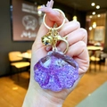 Detail of purple acrylic shell keychain with seashell starfish and gold bell accent - Purple Shell With Golden Hardware