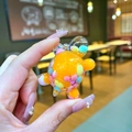 Close-up of a mini acrylic turtle pendant with colorful flowing beads and clear resin - Small Milk Bean Turtle / 1 Piece / Orange