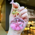 Detailed shot of a shell-shaped liquid glitter keychain with pink starfish and gold clasp - Pink Shell With Golden Hardware