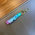 Detail of blue purple gradient strap keychain with Bubble art text and golden lobster clasp - Cyan