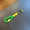 Détail d'un porte-clés patte de chat vert et jaune avec sangle silicone et fermoir doré - Vert