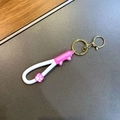 Détail du pendentif patte de chat rose avec fermoir doré et dragonne en silicone - Blanc