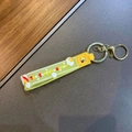 Detail of yellow silicone Sunshine Unicorn keychain strap with rainbow and cloud patterns - Unicorn Rainbow Strap / Yellow