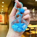 Macro detail of acrylic sea shell keychain with blue glitter oil and lobster clasp - Blue Shell With Matching Hardware