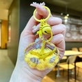 Detailed close-up of shell keychain with golden sand and mini seashell inside - Yellow Shell With Matching Hardware