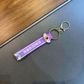 Purple PVC keychain strap with UNICORN text, rainbow charm and golden metal hardware - Purple Rainbow Wing Lanyard