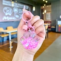 Dettaglio di un portachiavi a zampa di gatto in resina rosa con glitter e campanello - Stile Chiusura a Moschettone / Rosa