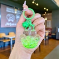 Detail of neon green cat paw liquid glitter keychain with bell and metal clasp - Lobster Clasp Style / Green