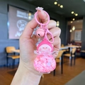 Detailed close-up of pink liquid pig keychain with glitters and bell on bag charm - Pink (Night Glow Snowflake Peach Pig)