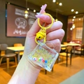 Close-up of a mini yellow handbag liquid keychain with sequins and bell accessory - Lobster Clasp Style / Yellow
