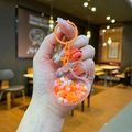 Close-up of orange acrylic heart keychain with internal beads and matching bell detail - Lobster Clasp Style / Colorful Metal (Orange)