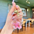 Detail of pink sakura bottle keychain with floating starfish, shell, and gold bell charm - Pendant Only (Without Chain) / Pink Flower With Golden Hardware