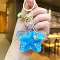 Star-shaped liquid acrylic keychain with blue starfish, shells and glitters inside - Blue Star With Golden Hardware