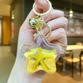 Star-shaped acrylic liquid keychain with yellow sand and small starfish detail - Yellow Star With Golden Hardware