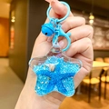 Star-shaped acrylic keychain with blue sand, starfish, shell and metal bell charm - Blue Star With Matching Hardware