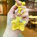 Star-shaped acrylic liquid keychain featuring yellow starfish and shell with a gold bell - Yellow Star With Matching Hardware