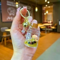 Detalle de un llavero de oso bubble tea con líquido flotante, lentejuelas y cascabel dorado - Estilo de Cierre de Mosquetón / Estilo Garrafa de Agua